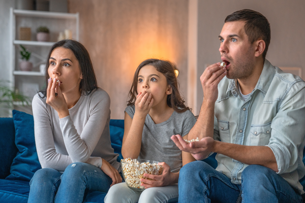 family watching a movie eating popcorn